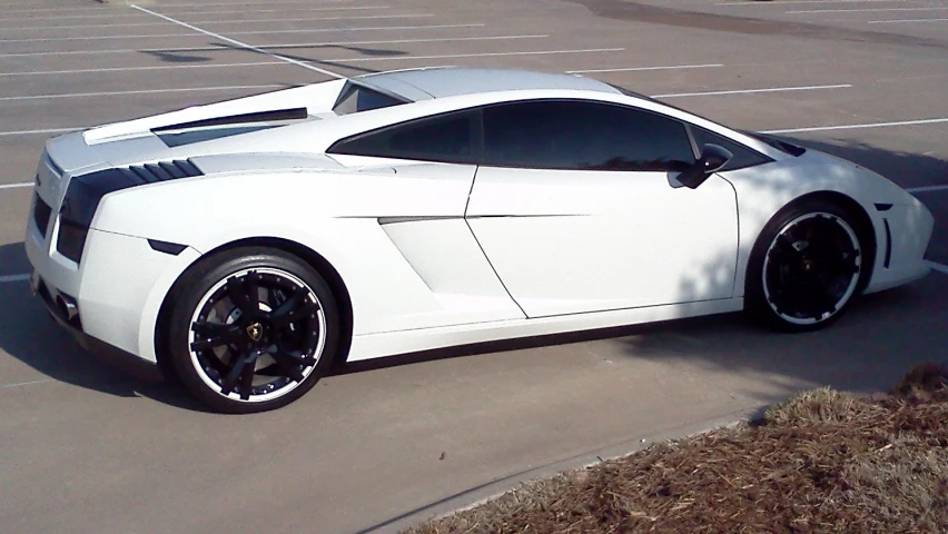 an exotic white sports car parked in a parking lot