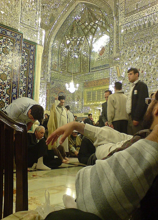 a group of men in prayer at an oriental building