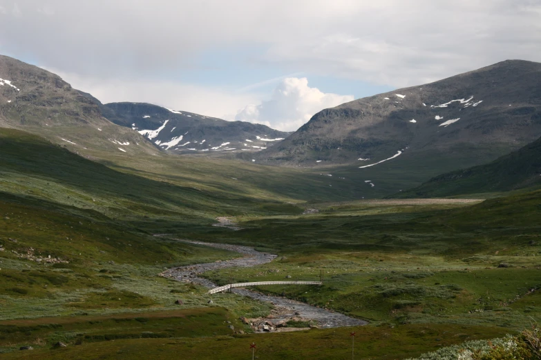 a view of a mountain valley with a small stream going through it