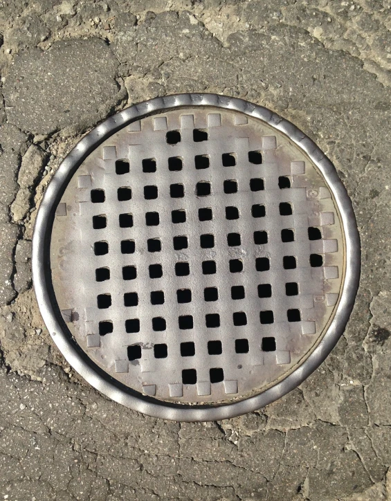 this is a metal grate on the ground with many small holes