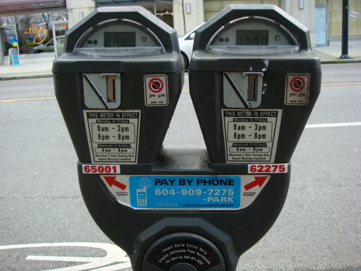 the parking meter is marked to pay phone numbers