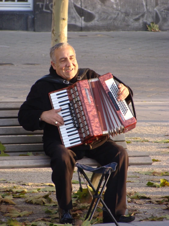 a man is sitting on a bench with an accordion