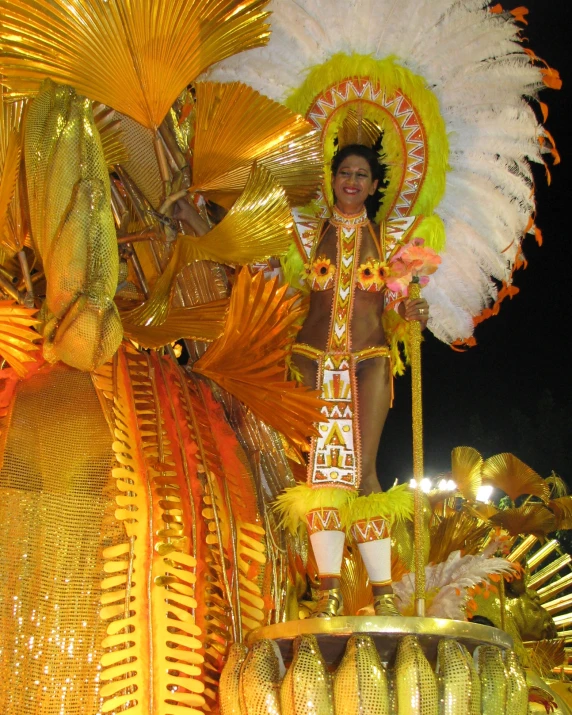 woman dressed in brightly colored costume, with flowers on top and feathers on her head