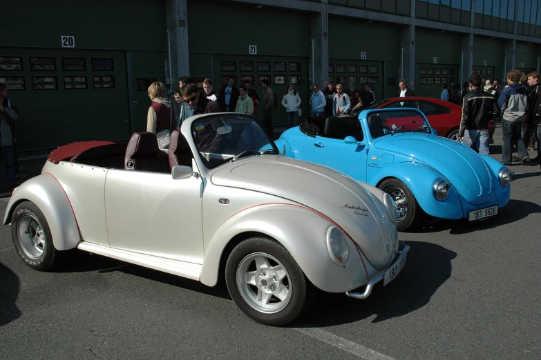 an old and older model v beetle bug in front of others