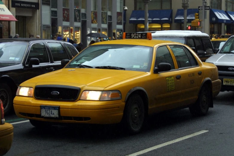 a taxi cab driving down a busy street