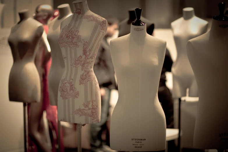 a group of womens dresses on mannequins lined up together