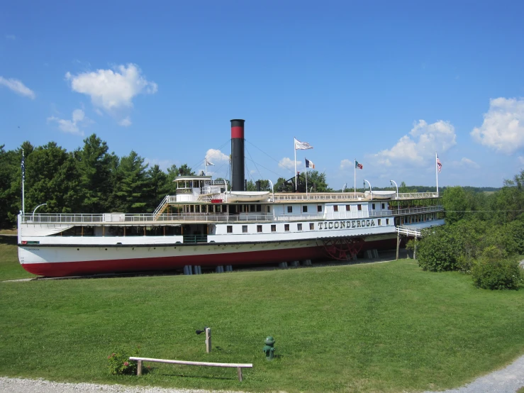 a white and red boat in the grass