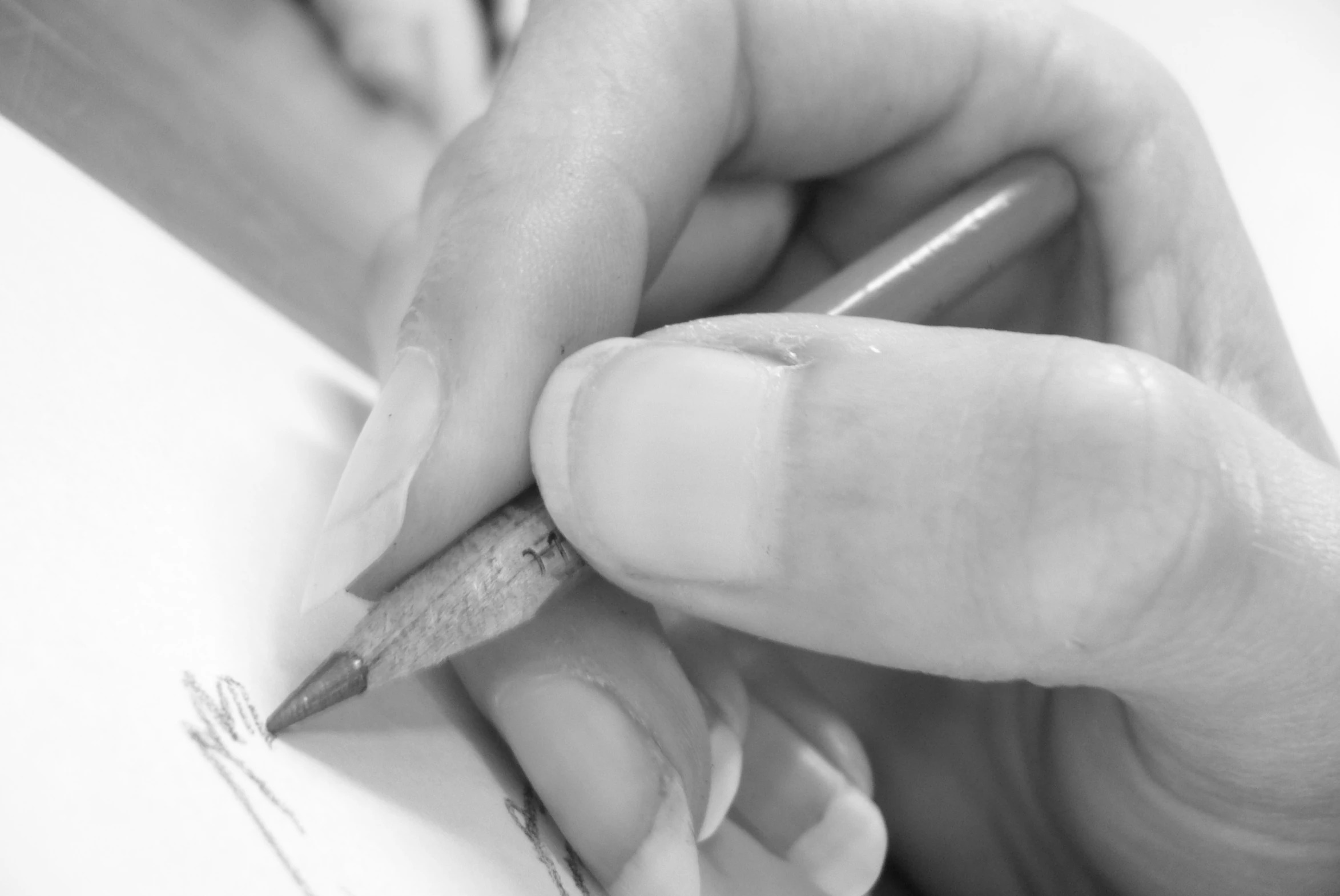 a person holding a pencil while they are writing