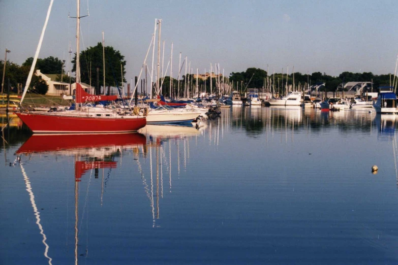 a red boat floats in the clear water