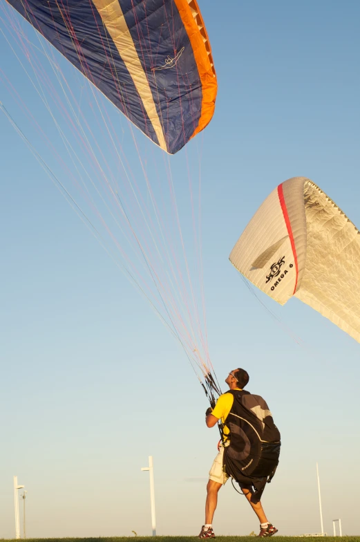 a man is holding on to his parachute in a grassy field