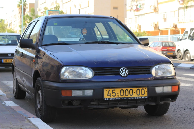 a dark blue volkswagen wagon with a yellow license plate on the front