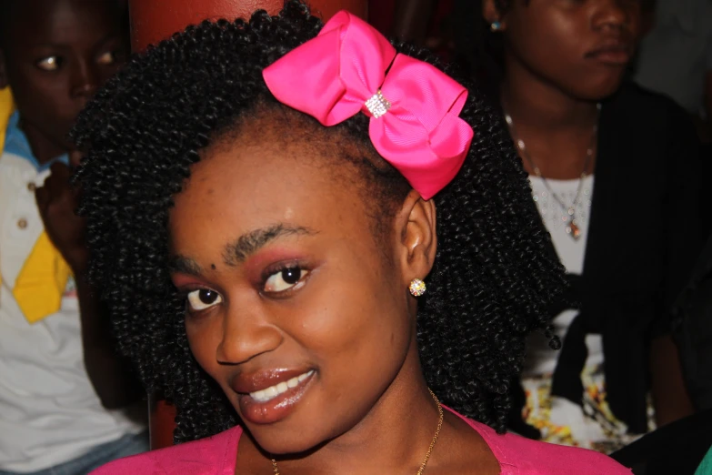 an afro girl with a pink bow in her hair
