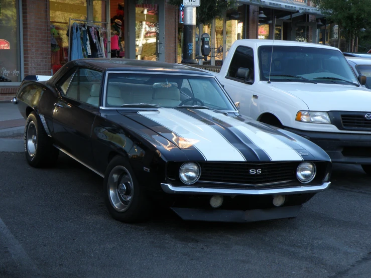 a car sitting in the street with other cars behind it