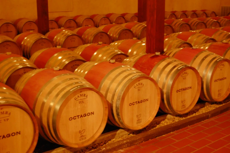 many wine barrels are stacked next to each other