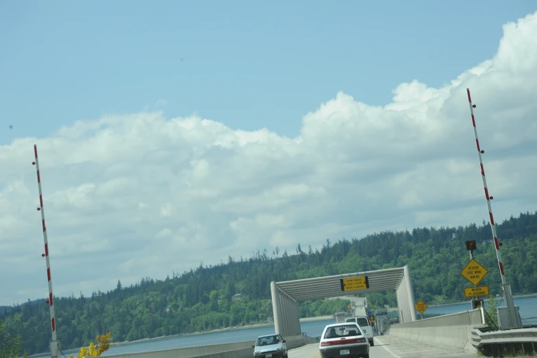 some cars driving over an open bridge