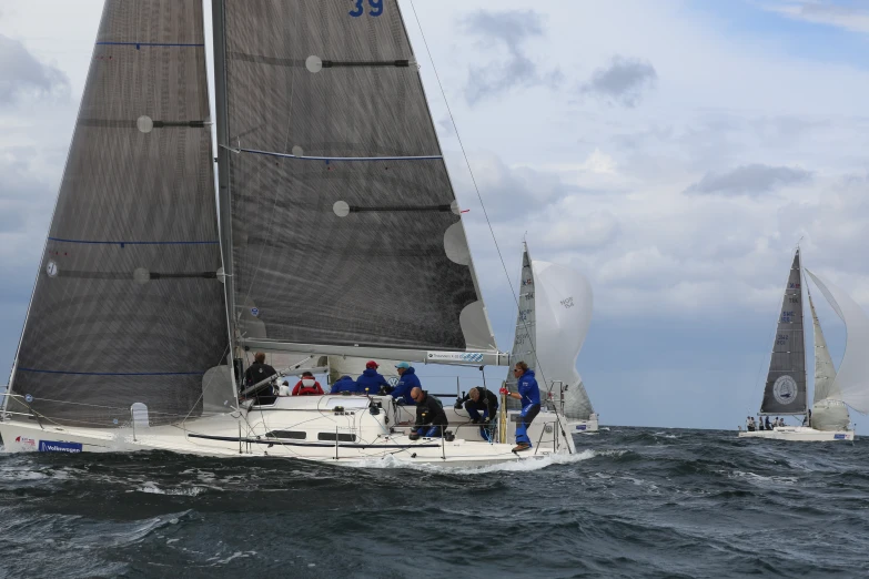 two boats with people on top sail through the water