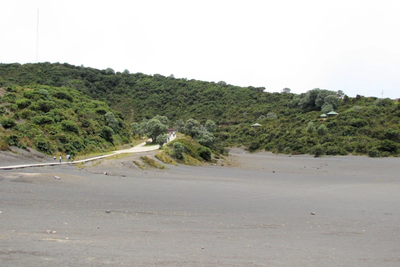 a sandy hill with some people walking on it