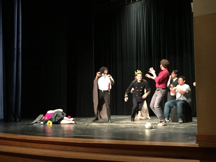 a man in a costume talks to young people at the microphone