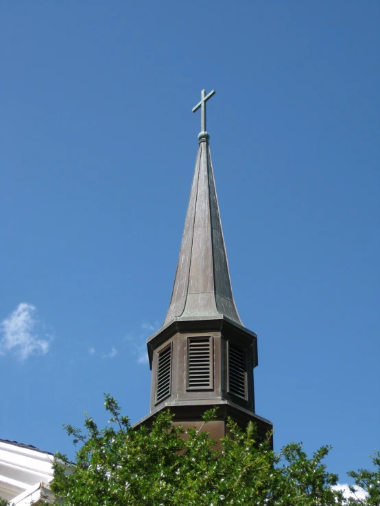 a very tall church tower with a cross on top