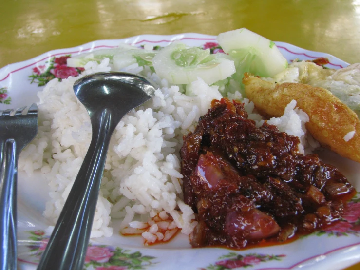 the plate has rice, meat and vegetables on it