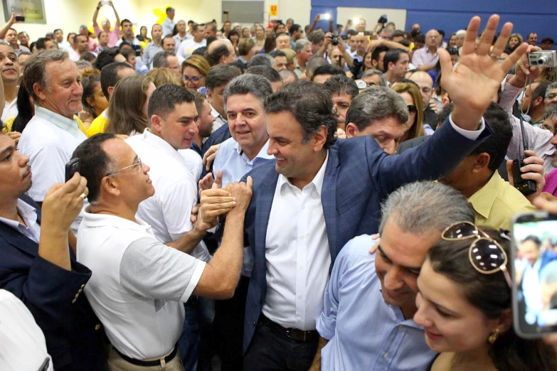 many people are taking pictures while a speaker gives the thumbs up