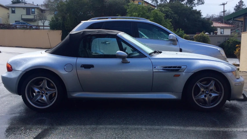 a silver sports car is parked next to another vehicle