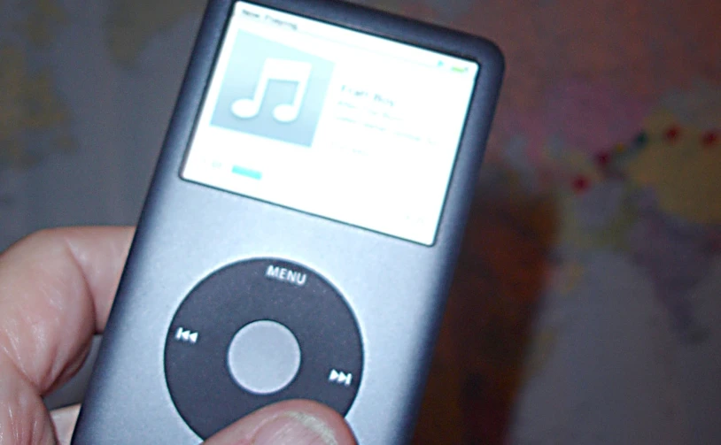 an image of someone holding a remote with an mp3 player in their hand