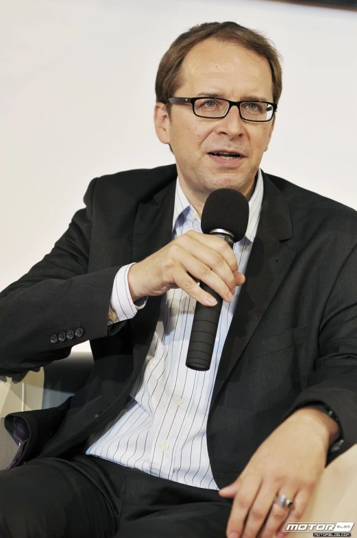 a man in a suit sitting and talking