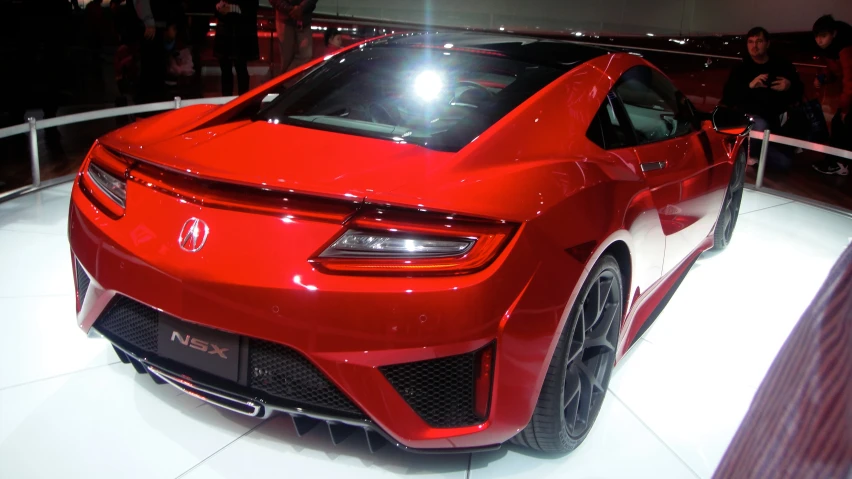 a red car that is parked in front of a man