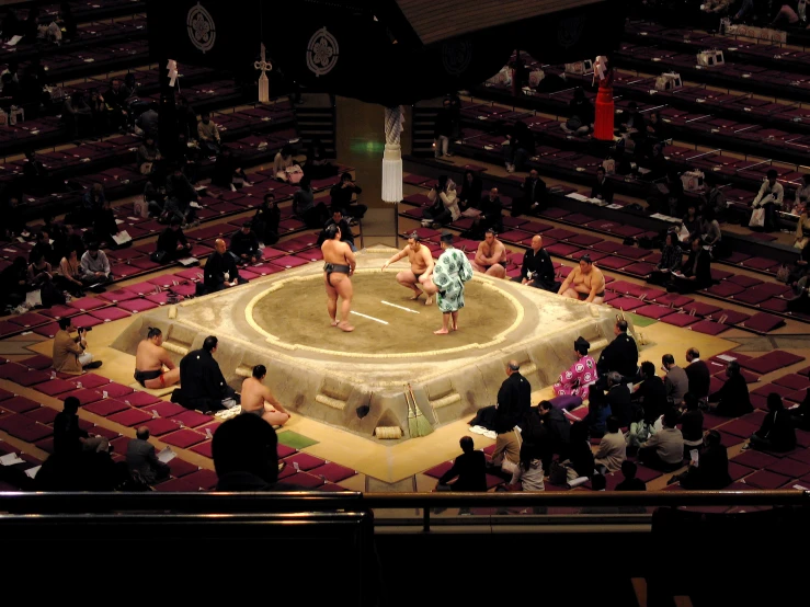 sumo wrestlers wrestling in an arena at a wrestling event