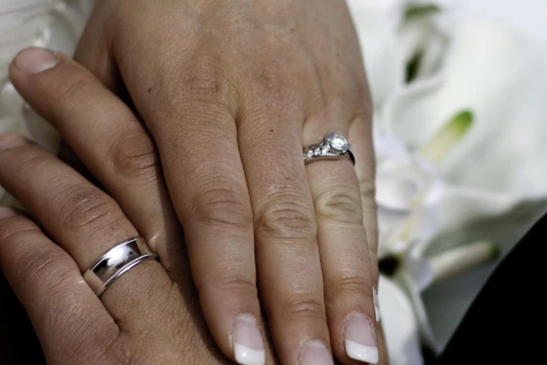 the newlywed couple's hands and their wedding rings