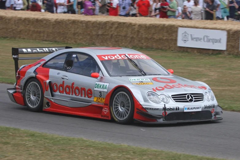 the silver and red car is driving on the track