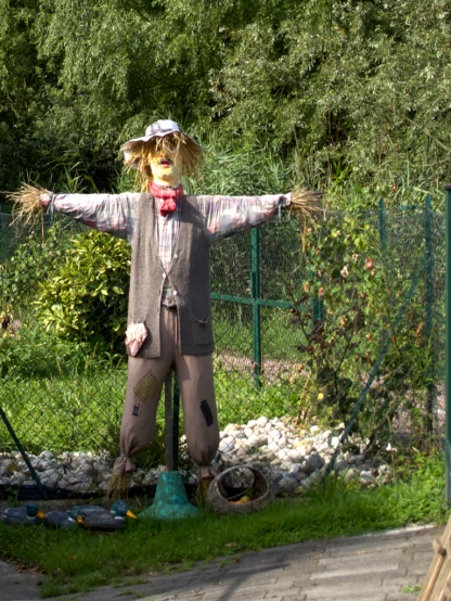 a scarecrow is standing on the grass