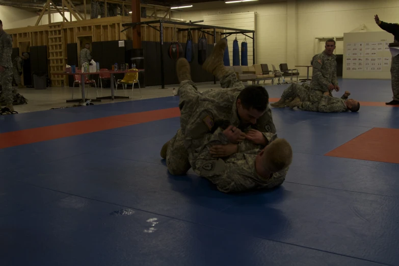 two soldiers laying on the ground working together