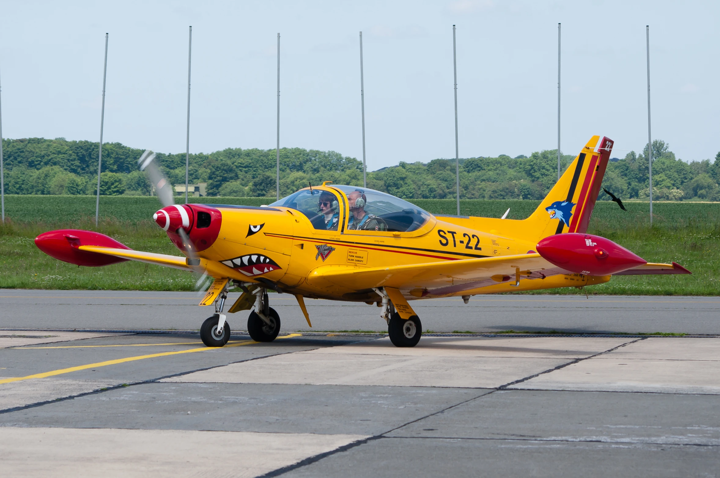 the yellow and red airplane is taking off