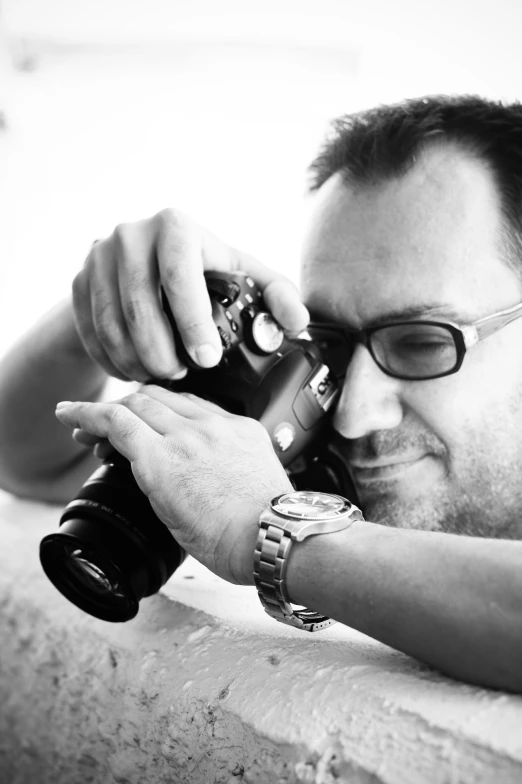 man wearing glasses and taking a picture with a camera