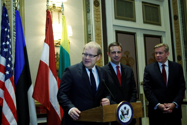 the three men are posing for a picture behind the podium