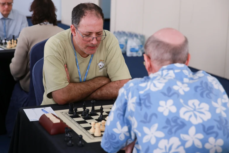 a man sitting at a table playing chess