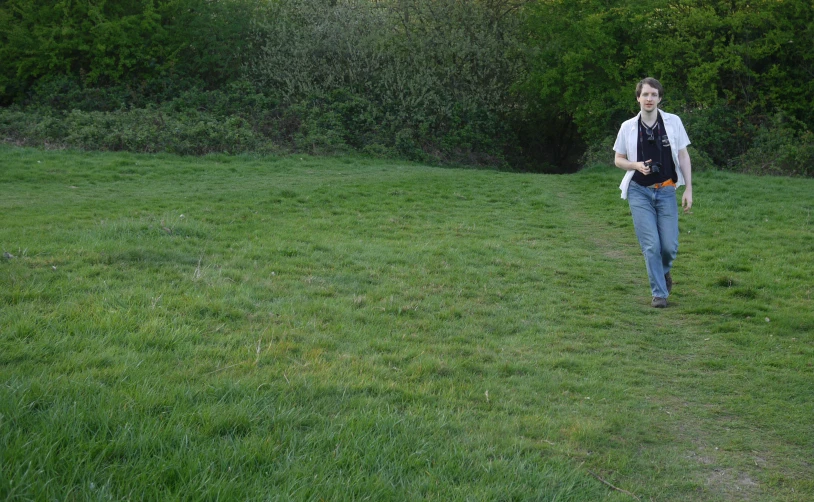 a young man in a field with his back to the camera