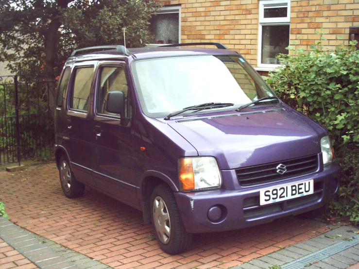 a small purple van is parked in a driveway