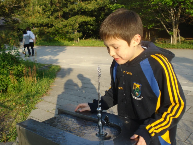 a  in a black and yellow jacket is placing his cross into the statue