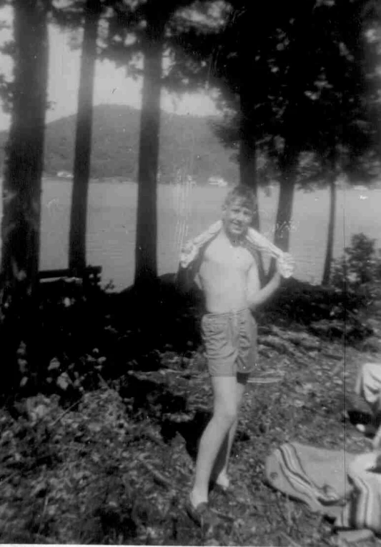 a person standing next to some trees by a body of water