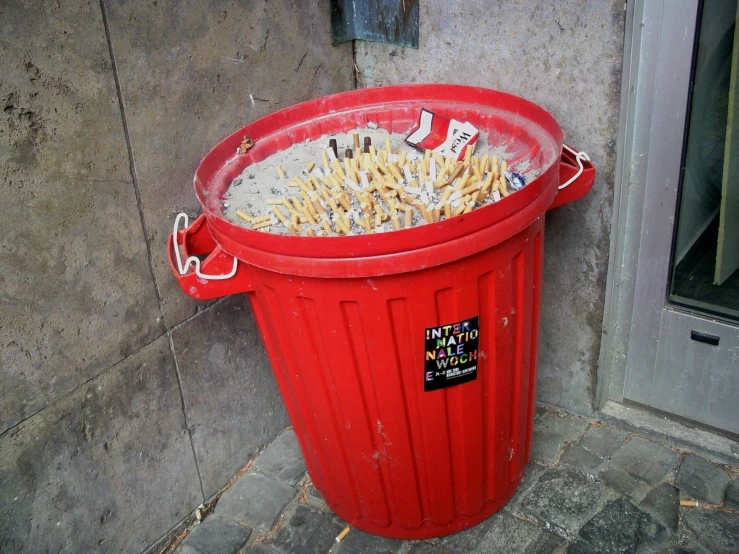 a red trash can filled with pennets in it