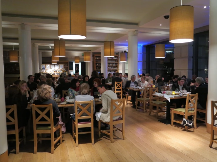 many people are sitting at wooden tables in an old liry