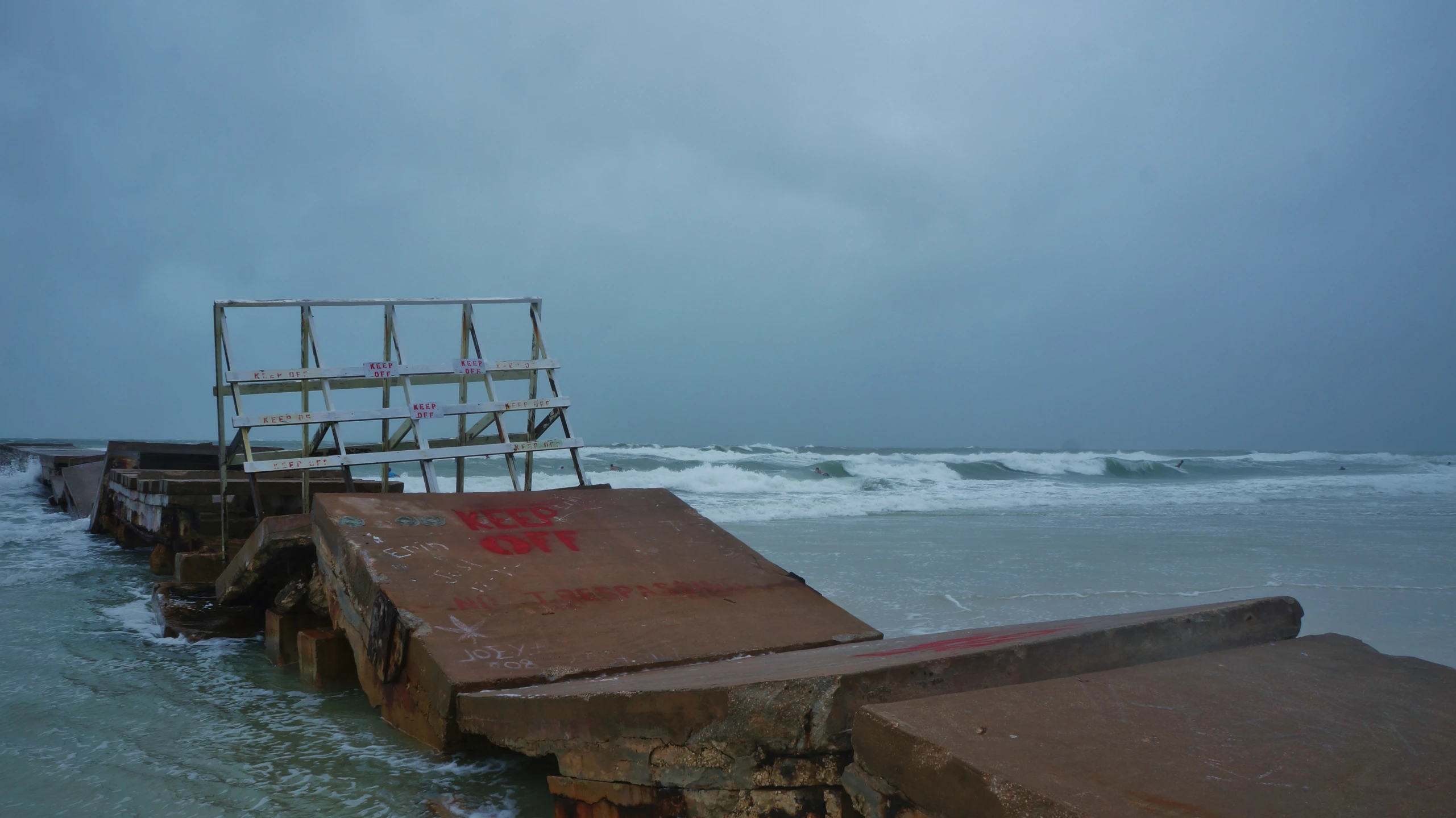 a broken metal and rusted structure in the middle of the ocean