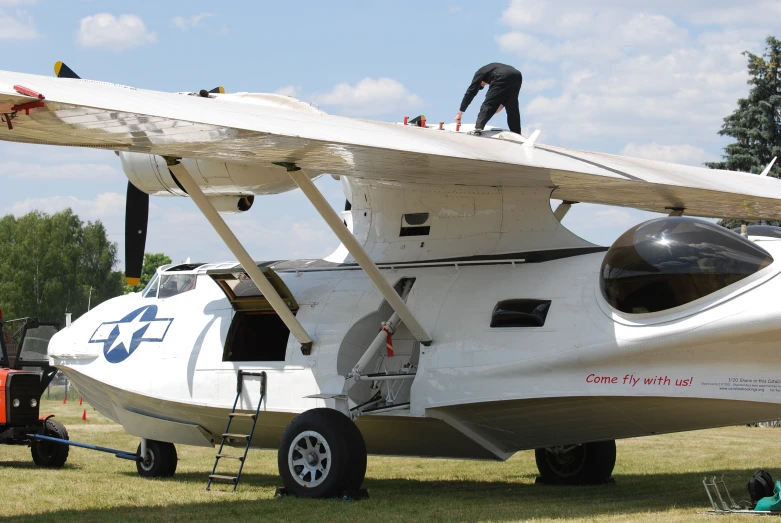 a person is standing on the top of an airplane