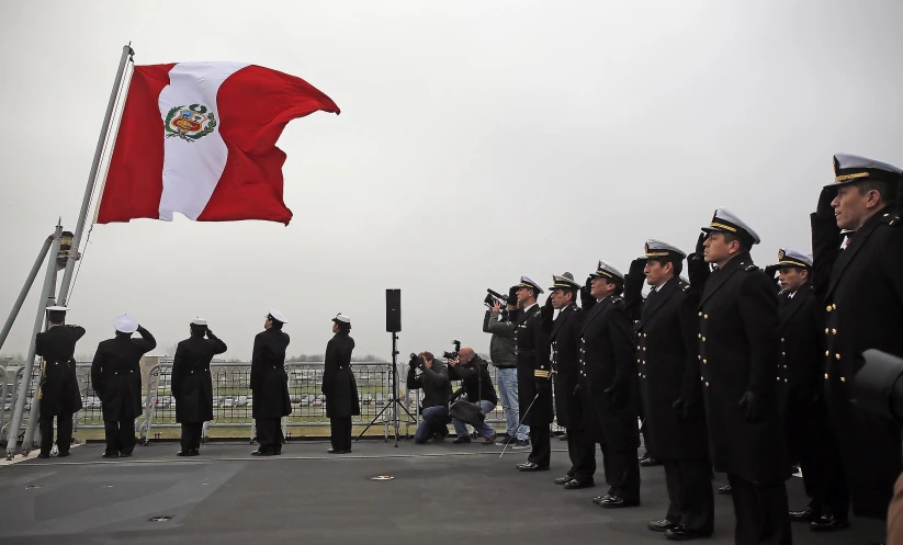 military men stand in front of the flag on display