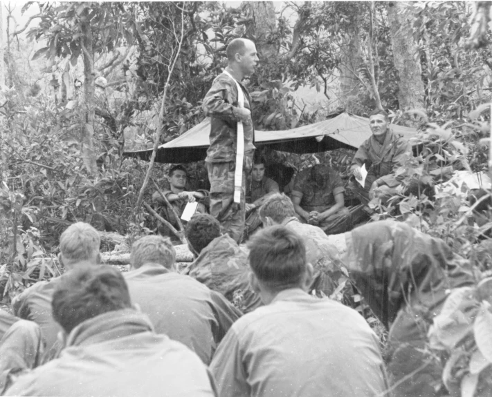 many people and one person on a small raft in the middle of a forest