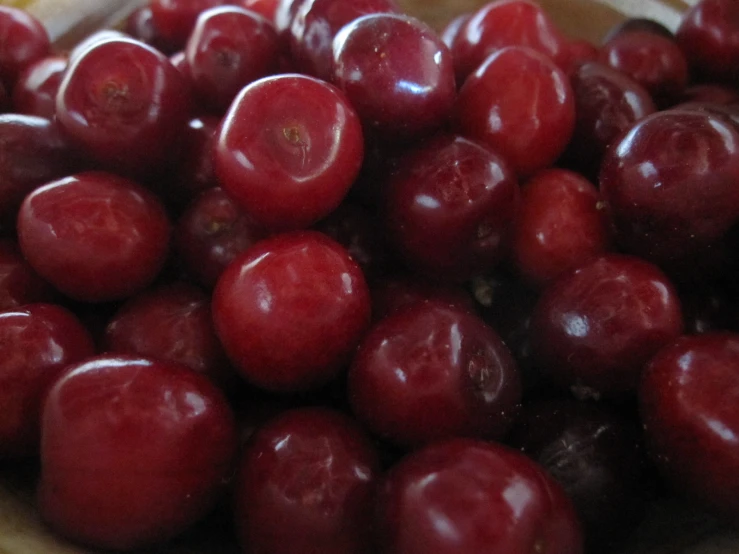 a brown bowl filled with fresh ripe cherries