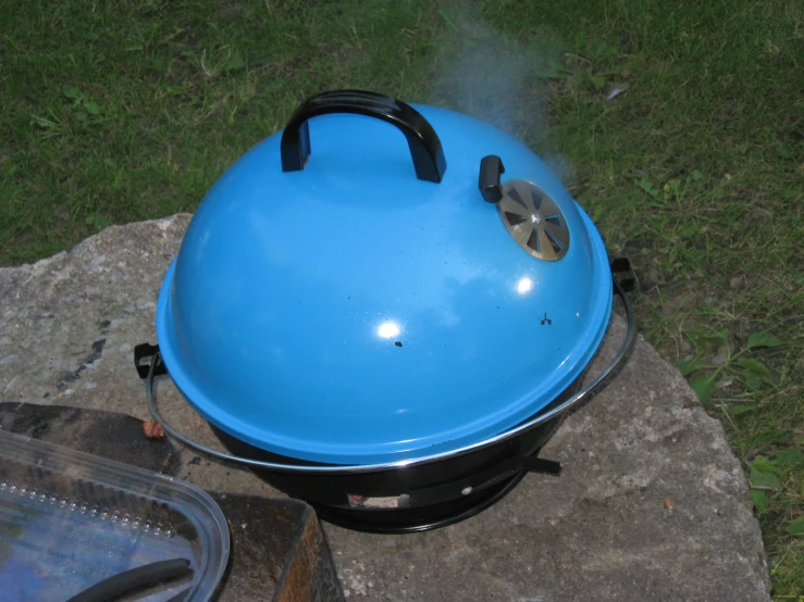 a blue egg on the ground being placed over by a person